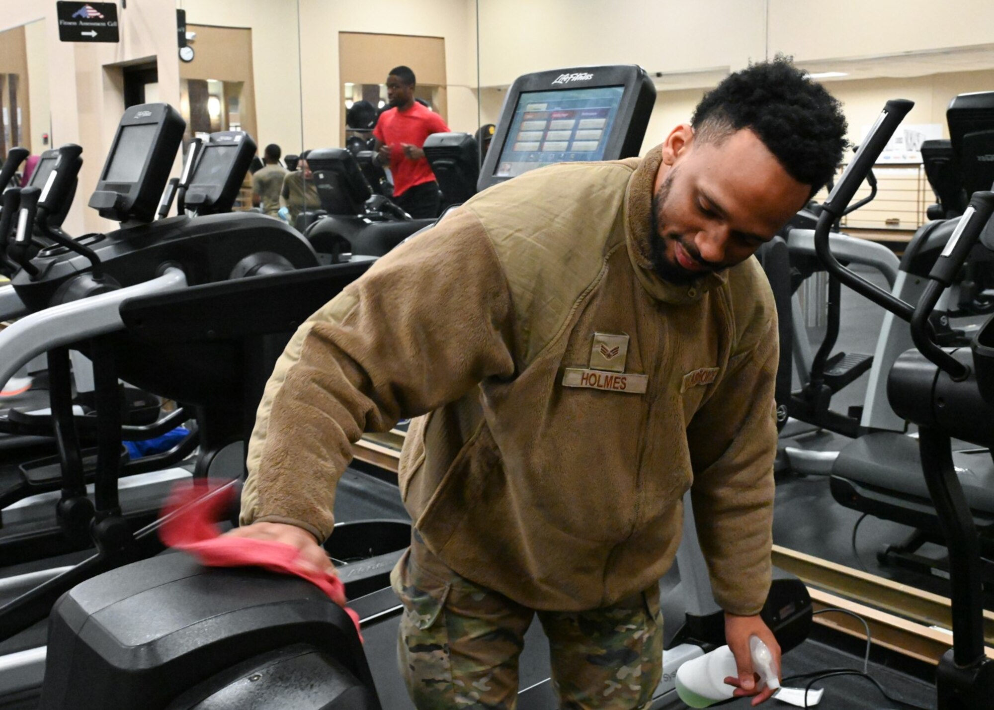 Senior Airman Zachary Holmes, Services Airman with the 509th Force Support Squadron,  Wipes down gym equipment at Whiteman Air Force Base, Missouri, January 20, 2023. Holmes cleans gym equipment to ensure people exercise on sanitary machines. (U.S. Air Force photo by Senior Airman Nash Truitt)