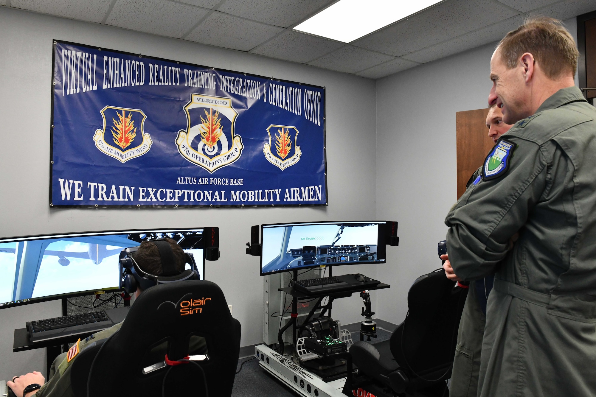 U.S. Air Force Maj. Gen. Corey Martin, 18th Air Force commander, watches as a student from the 97th Training Squadron operates a flight simulator at Altus Air Force Base, Oklahoma, Jan. 26, 2023. The use of flight simulators provide a safe opportunity for student pilots to practice their initial flying skills. (U.S. Air Force photo by Airman 1st Class Miyah Gray)