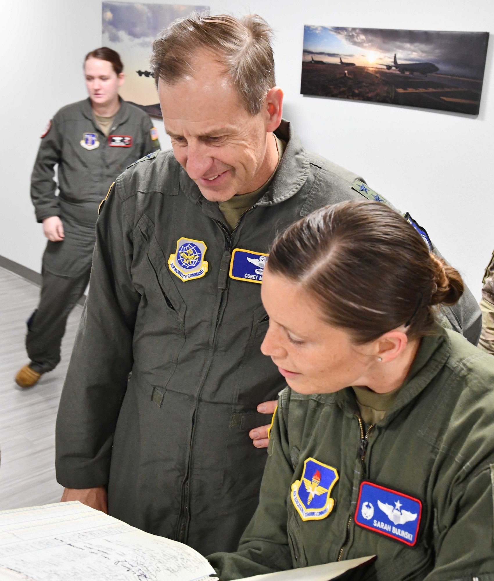 U.S. Air Force Lt. Col. Sarah Bulinski, 54th Air Refueling Squadron (ARS) commander, showcases a record of instructors to Maj. Gen. Corey J. Martin, 18th Air Force commander, at Altus Air Force Base (AAFB), Oklahoma, Jan. 26, 2023.  The log records every formal training unit instructor from the 54th ARS from 1987 to present day. (U.S. Air Force photo by Airman 1st Class Miyah Gray)