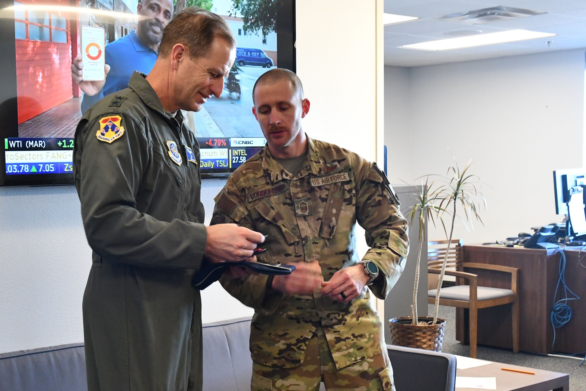 U.S. Air Force Maj. Gen. Corey Martin views a boom operator coin given to him by Senior Master Sgt. Joseph Vondohlen, 56th Air Refueling Squadron senior enlisted leader, at Altus Air Force Base, Oklahoma, Jan. 26, 2023. One side of the coin features a KC-46 Pegasus boom overlapping a shield and a Boom Operator Association heritage logo on the other side. (U.S. Air Force photo by Airman 1st Class Miyah Gray)