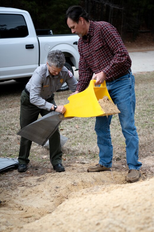 Annette Dotson, left, park ranger, and Glenn Kowalski, natural resources program manager, participate in a sandbag demonstration during dam safety training at the Richard B. Russell Dam on Feb. 1, 2023. USACE photo by Mel Orr.