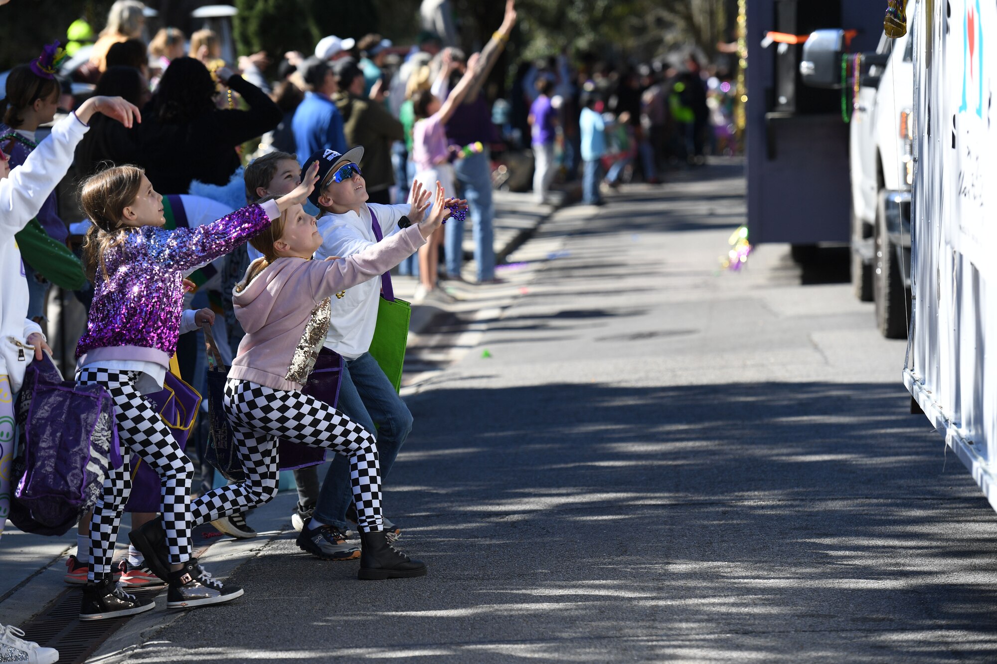 Parade attendees reach for thrown Mardi Gras beads during the Ocean Springs Elks Mardi Gras Parade at Ocean Springs, Mississippi, Feb. 4, 2023.