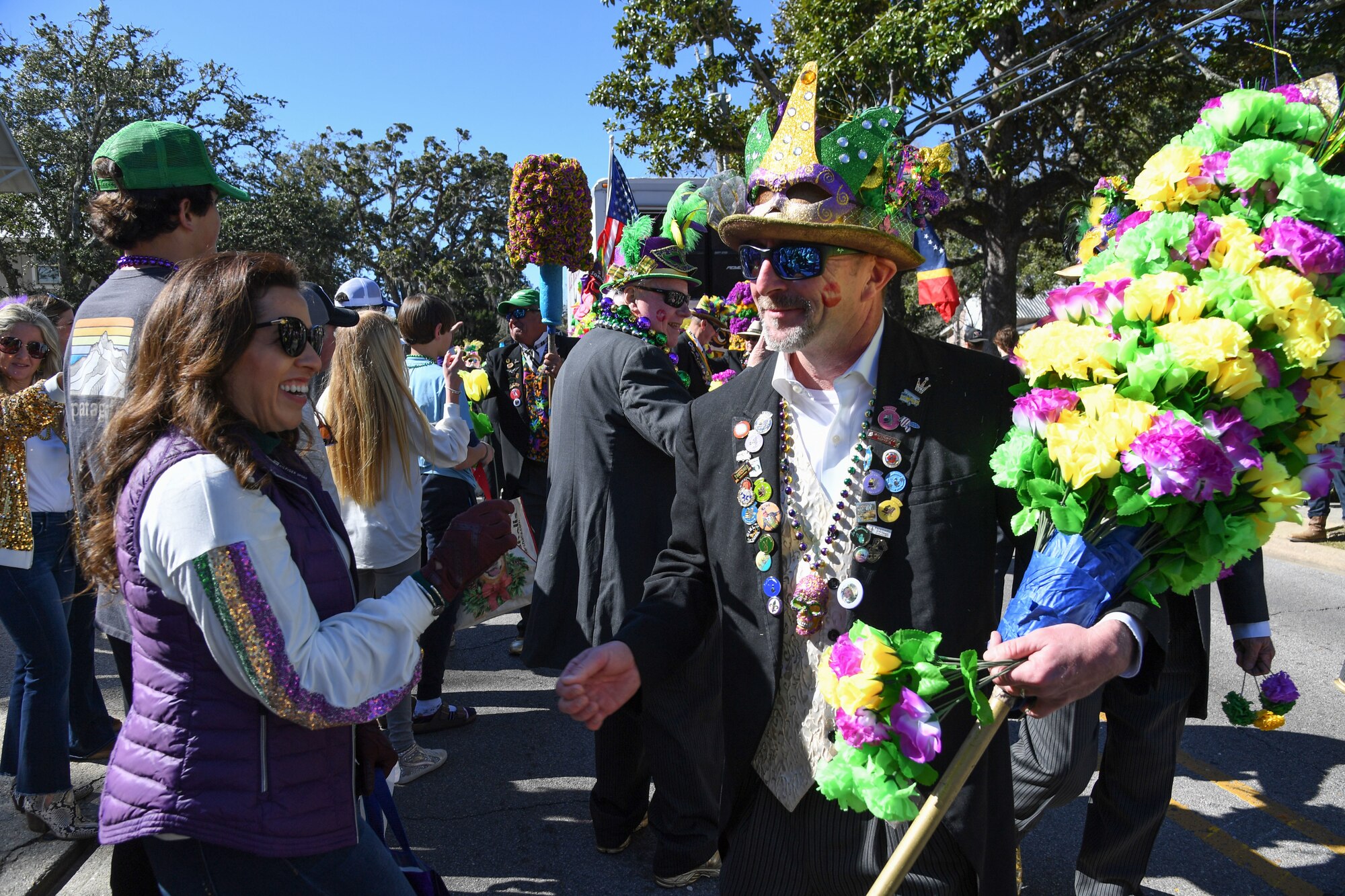 Mayra Allen, wife of U.S. Air Force Col. Jason Allen, 81st Training Wing commander, receives a flower from a member of the Ole Biloxi Marching Club during the Ocean Springs Elks Mardi Gras Parade at Ocean Springs, Mississippi, Feb. 4, 2023.