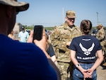 A proud parent records his daughter meeting her first general officer, Lt. Gen. Tony Bauernfeind, commander of U.S. Special Operations Command, during a recruitment event at Talladega Superspeedway, Ala., April 24, 2022. The general visited the NASCAR race where he performed a swearing-in ceremony for 14 future Airmen. Air Force Recruiting Service launched an expanded, redesigned version of airforce.com, Feb. 6, 2023. (U.S. Air Force photo by Samuel King Jr.)