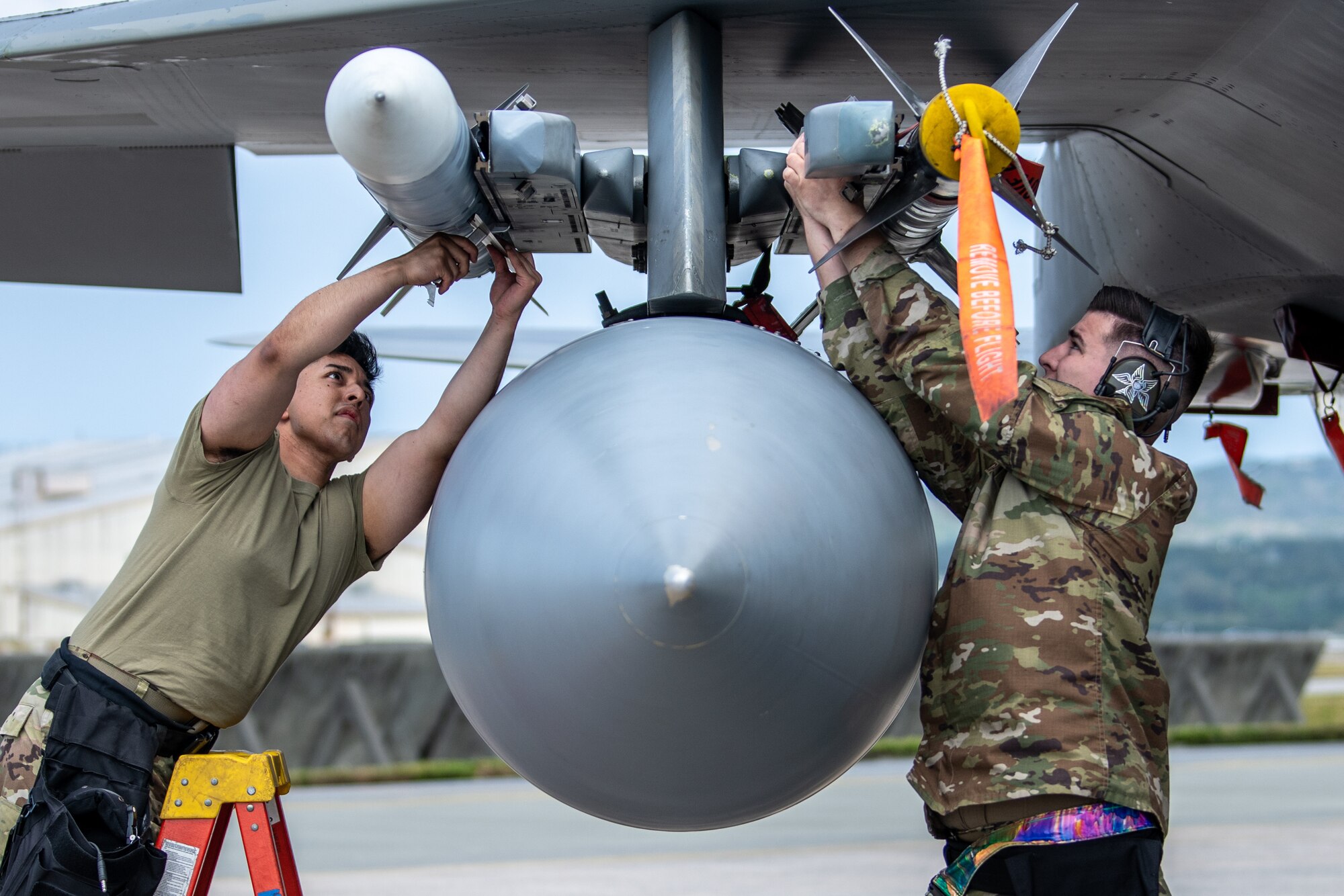 Airmen attach missiles to a jet.