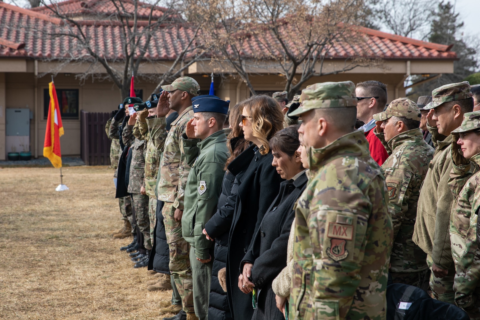 South Korean and American military officials along with distinguished guests  stand in honor of the U.S. National Anthem during the 72nd annual Battle of Hill 180 Ceremony at Osan Air Base, South Korea, Feb. 2, 2023.