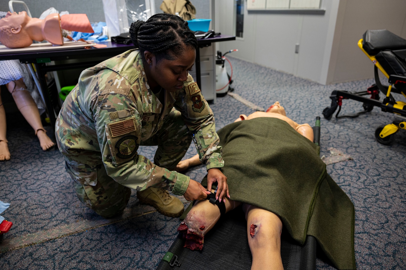 U.S. Air Force Tech. Sgt. Renique Carey, 49th Medical Group force health management noncommissioned officer in charge, applies a tourniquet on a test dummy at Holloman Air Force Base, New Mexico, Jan. 27, 2023. By using the Medic-X program, the 49th MDG ensures that non-patient-care career fields within the group receive proper training in case of large-scale emergencies. (U.S. Air Force photo by Airman 1st Class Isaiah Pedrazzini)