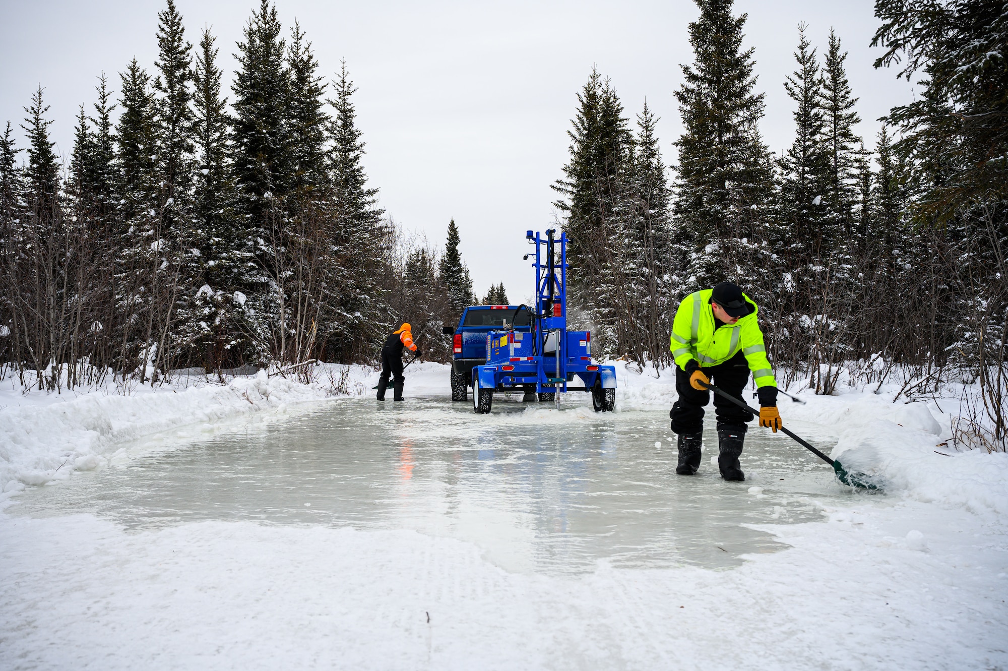 U.S. Air Force Senior Airman Zachary Lynch, left, a 99th Civil Engineer Squadron pavements and construction journeyman, and Staff Sgt. Dawson Templer, a 19th Civil Engineer Squadron structural craftsman, reinforce the ice bridge’s snow berm at the Blair Lake Range Complex, Alaska, Jan. 26, 2023.
