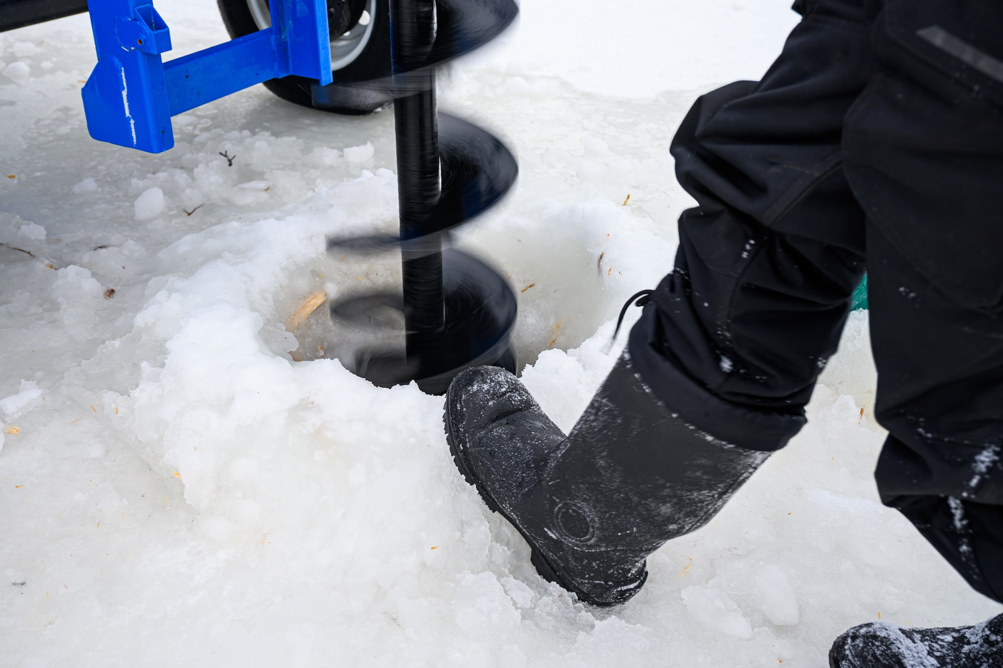 U.S. Air Force Senior Airman Zachary Lynch, a 99th Civil Engineer Squadron pavements and construction journeyman, creates a snow berm next to a BH-18 ice drill at the Blair Lake Range Complex, Alaska, Jan. 26, 2023.