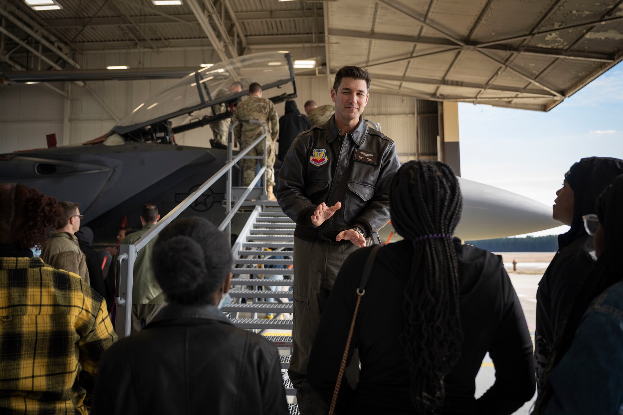 Maj. Ryan Fishel, 336th Fighter Squadron pilot, briefs Goldsboro High School students about the F-15E Strike Eagle at Seymour Johnson Air Force Base, North Carolina, Jan. 27, 2023. The students are part of clubs at their school, such as Future Business Leaders of America, the Student Government Association and the Distributive Education Clubs of America.