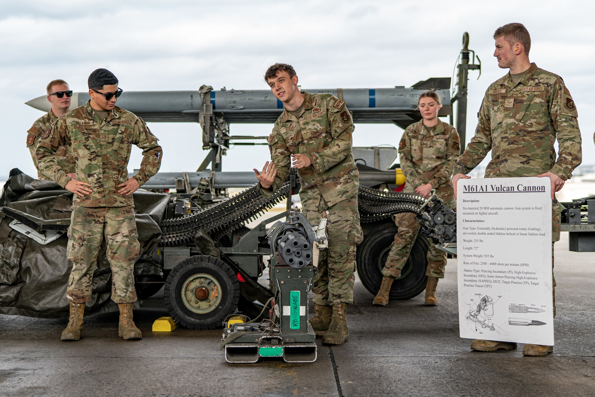 An Airman explains a machine gun.