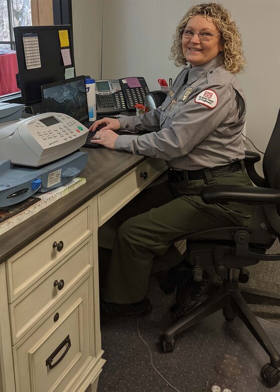 Park Ranger Judy Daulton sits at a desk in the visitors office.