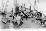 U.S. Navy diving crew at work on the ship's wreck, in 1898, seen from aft looking forward. U.S. Naval History and Heritage Command Photograph.