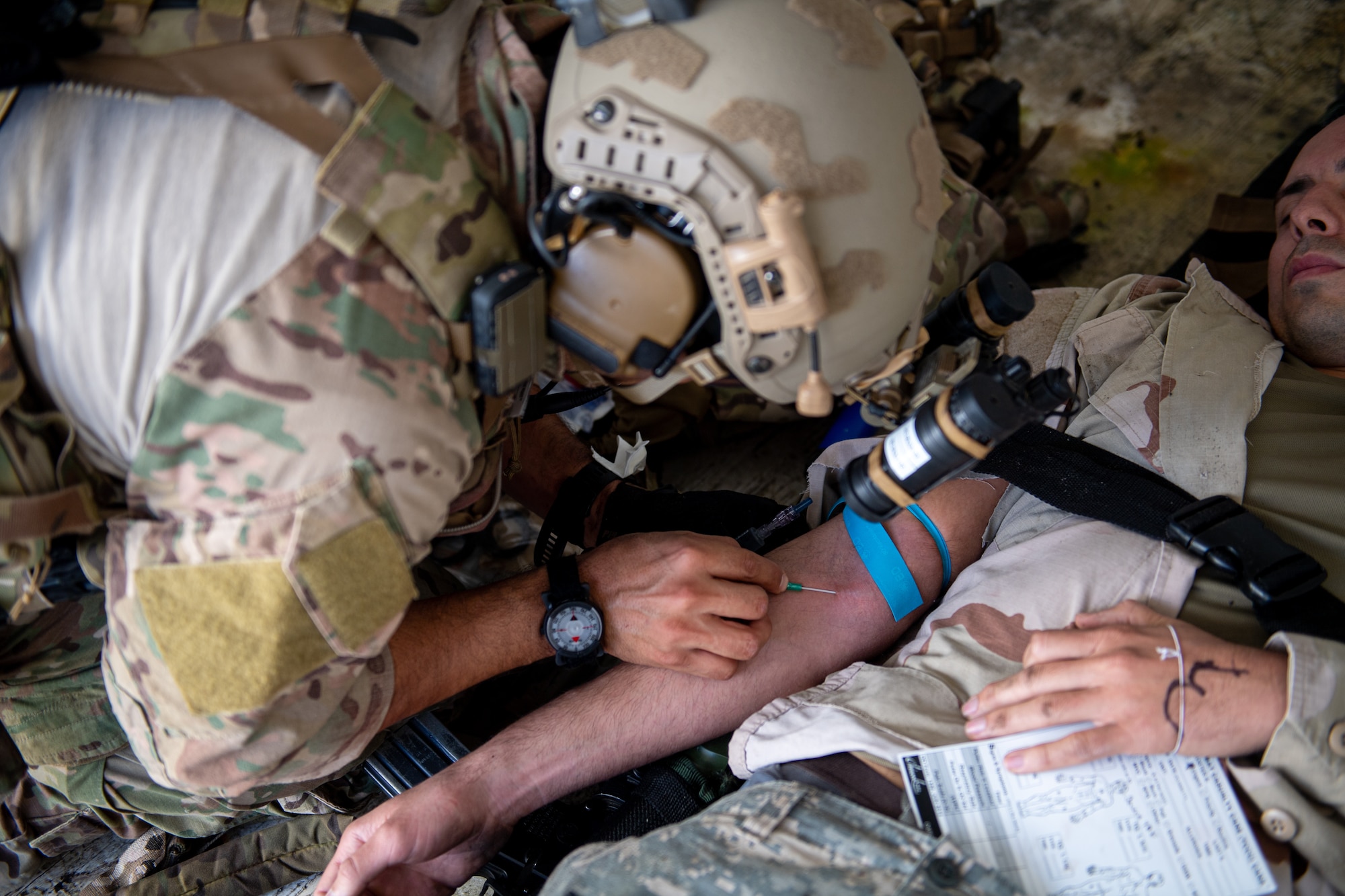 An Airman places a needle into a patient's arm.