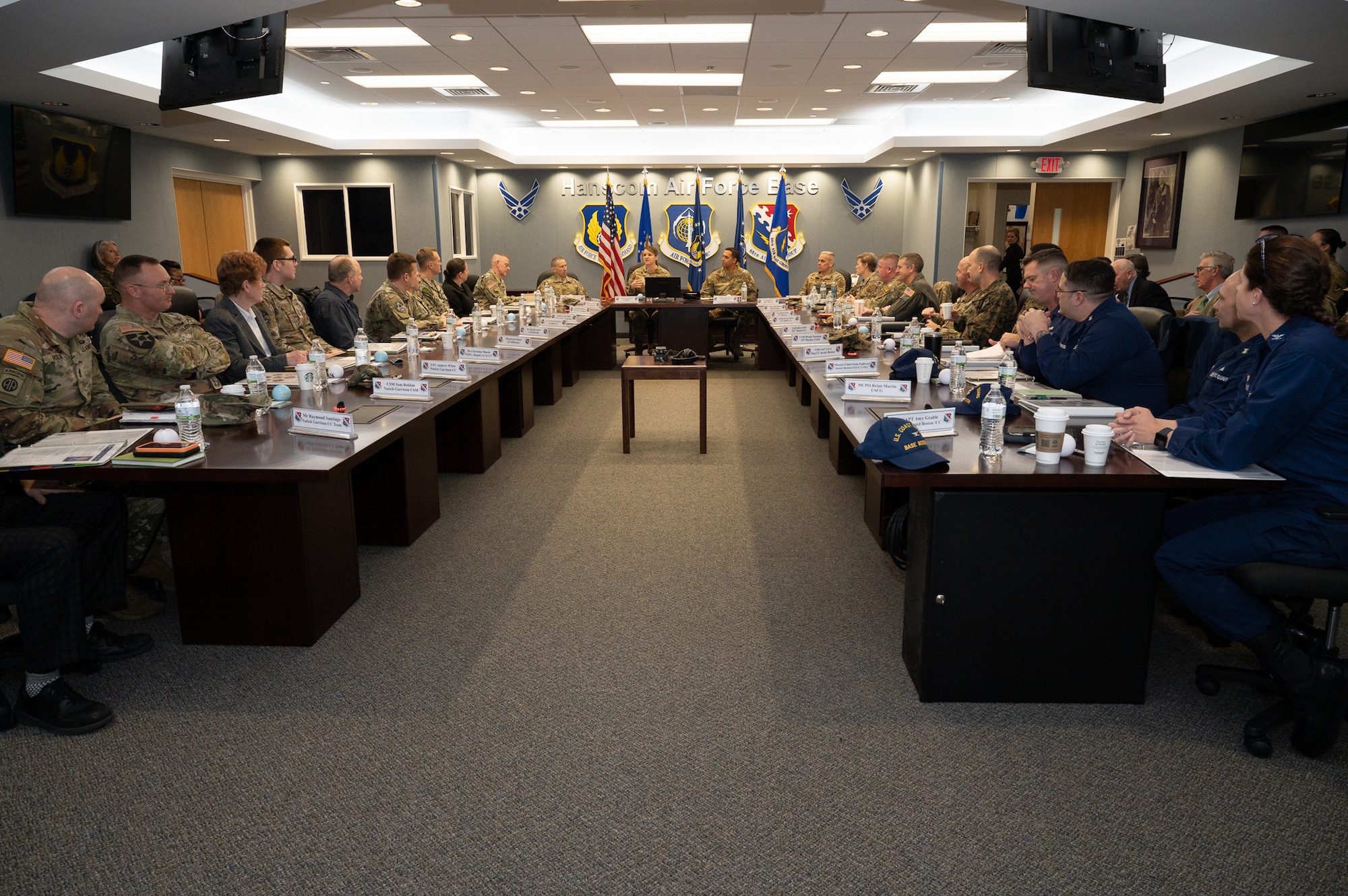 Military leaders from all branches sit around the horse-shoe shaped conference table at the Brown Building