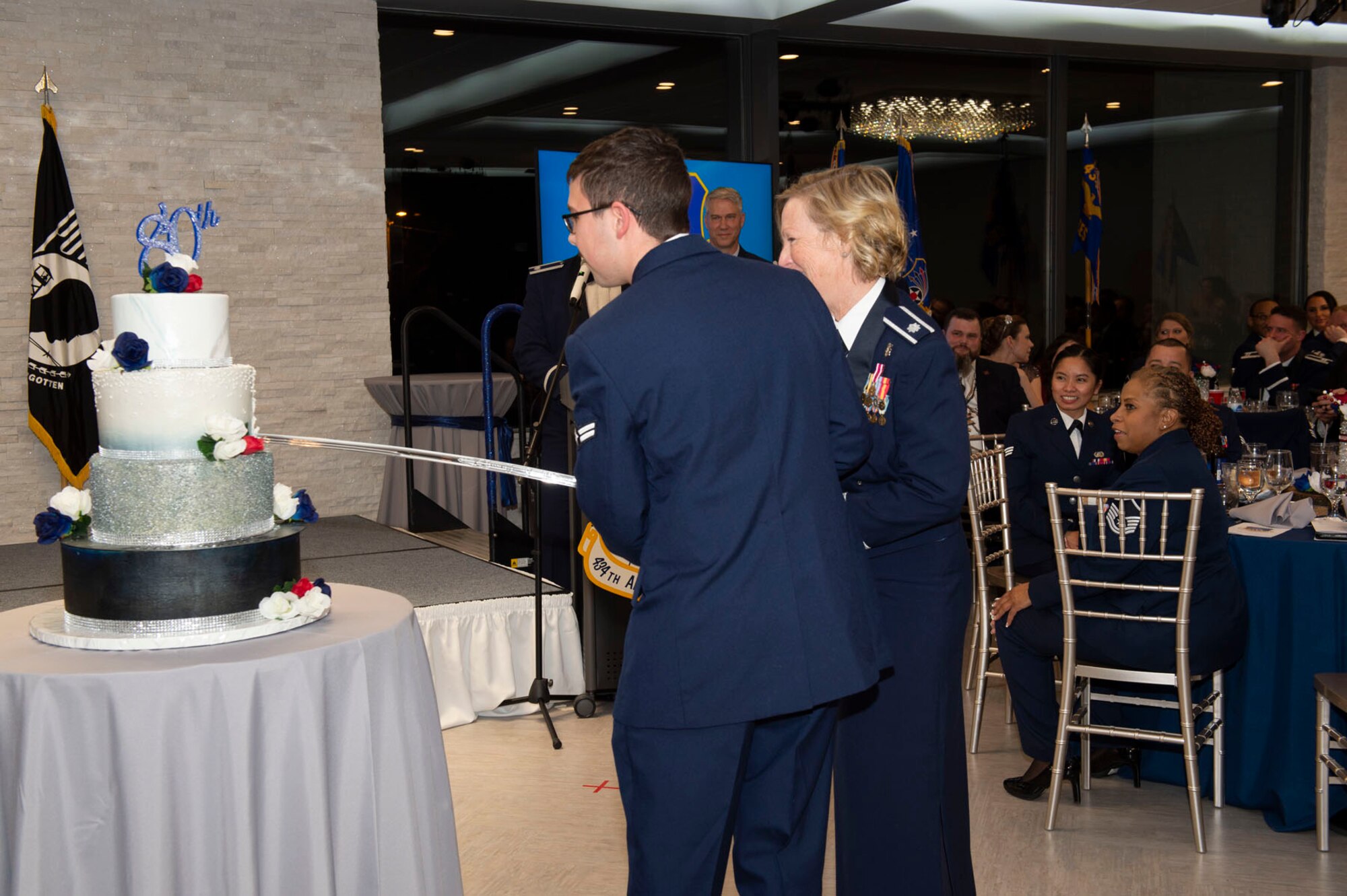 Lt. Col. Kelli Bermudez, 434th Aerospace Medicine Squadron, and Airman1st Class Justin Rowland, 49th Aerial Port Squadron, cut the anniversary cake during the ball. Attendees celebrated both the unit and base's long and storied history. Photo by Master Sgt. Rachel Barton.