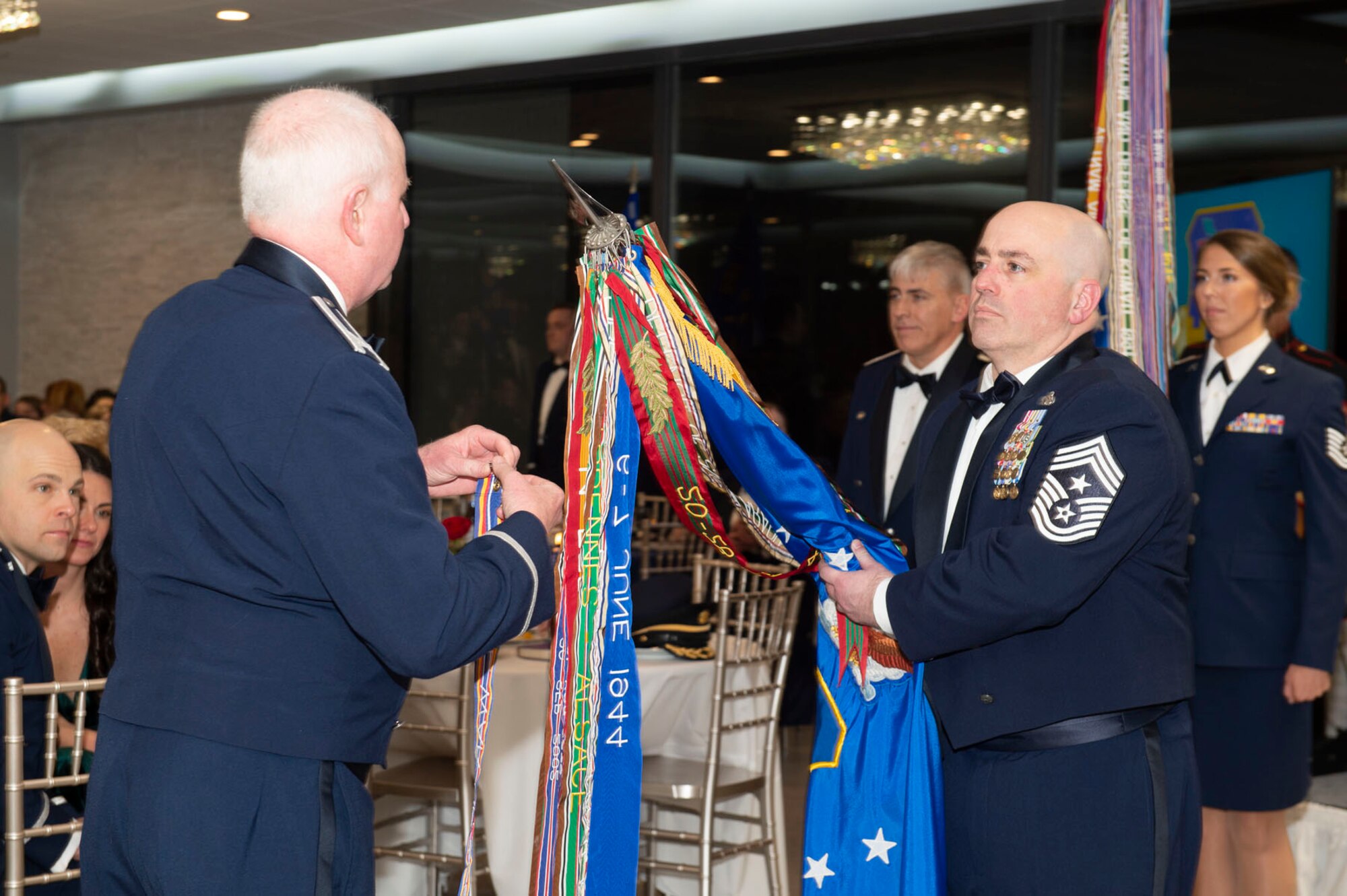 Col. Thom Pemberton, 434th ARW commander, attaches a Global War on Terror service streamer to the wing guidon being held by Chief Master Sgt. Brian Jensenius, 434th ARW command chief during a pinning ceremony held during the 80th Anniversary Ball. After Pemberton pinned on the streamer to the wing's guidon, each squadron attached one to their own guidon. Photo by Master Sgt. Rachel Barton