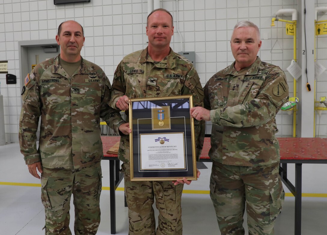 Army Col. Gary Dwayne Lewis poses Maj. Gen. Haldane B. Lamberton, Adjutant General-Kentucky, and Col. Michael Armstrong, 63rd Theater Aviation Brigade commander, after he was presented with the Kentucky Distinguished Service Medal during the retiree's breakfast at the Army Aviation Support Facility on Boone National Guard Center in Frankfort Dec. 9, 2022.