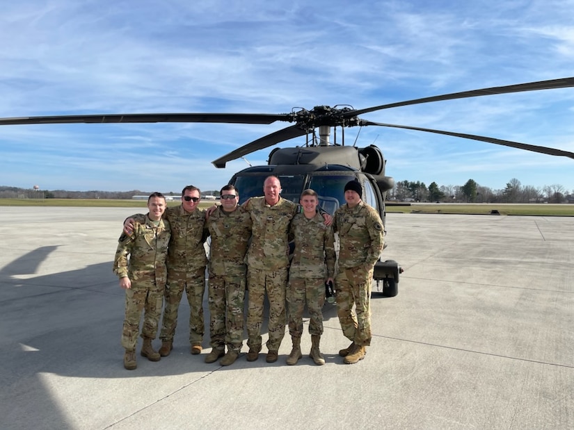 Army Col. Gary Dwayne Lewis poses for a group photo with his son and fellow crew members following his final flight Dec. 7, 2022, in London, Ky. Lewis wrapped up an illustrious Guard career with over 7,700 hours of flight time as an aviator.