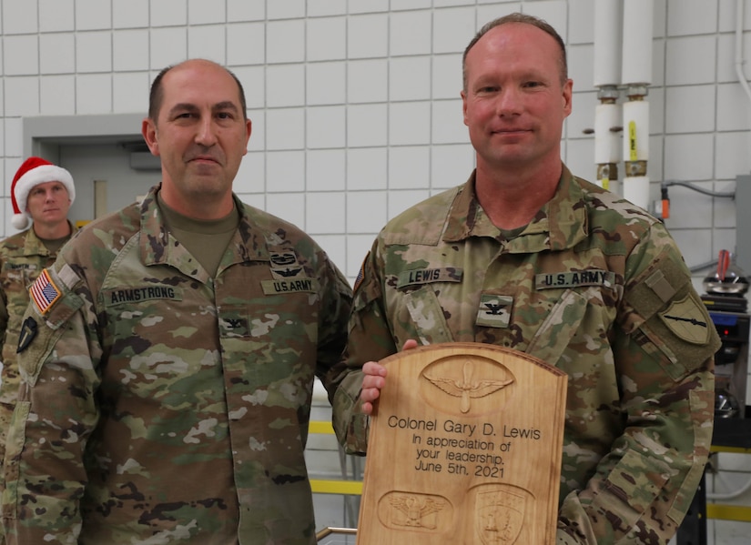Army Col. Gary Dwayne Lewis receives a plague of appreciation from Col. Michael Armstrong, 63rd Theater Aviation Brigade commander, for his service to the Guard during the retiree's breakfast at the Army Aviation Support Facility on Boone National Guard Center in Frankfort, Ky.