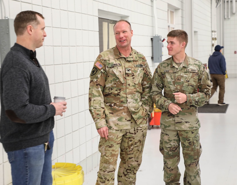 Army Col. Gary Dwayne Lewis stands next to his son Jonah, who recently joined the Guard, during the retiree's breakfast at the Army Aviation Support Facility on Boone National Guard Center in Frankfort, Ky.