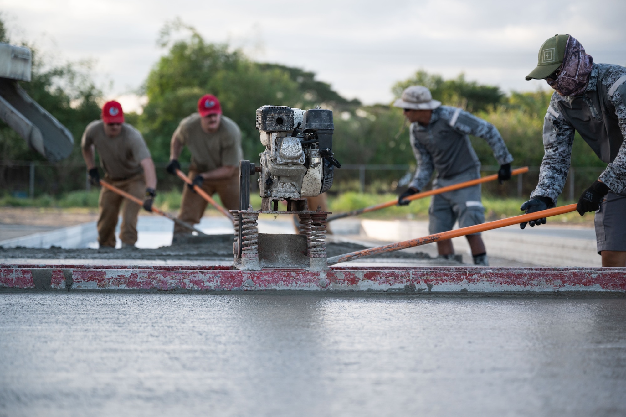 Airmen from the 819th RED HORSE Squadron out of Malmstrom Air Force Base, Montana, assist the Philippine Air Force in pouring concrete as part of a Field Training Event at Basa Air Base, Philippines, January 25, 2023. This event was one of many that took place in the Philippines over the course of two weeks to include exchanging knowledge and best practices on maintenance, hot pit refueling, airfield damage repair, and logistics. (U.S. Air Force photo by Tech. Sgt. Hailey Haux)