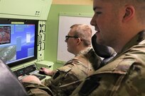 U.S. Army Spc. Hunter Seaborg, a UAS operator with Delta Company, 103rd Brigade Engineering Battalion, 56th Stryker Brigade Combat Team, 28th Infantry Division, flies an RQ-7 Shadow on a simulator while Sgt. Tyler Beck provides coaching at the Unmanned Aircraft System Operations Facility at Fort Indiantown Gap, Jan. 30, 2023. (U.S. Army National Guard photo by Capt. Travis Mueller)