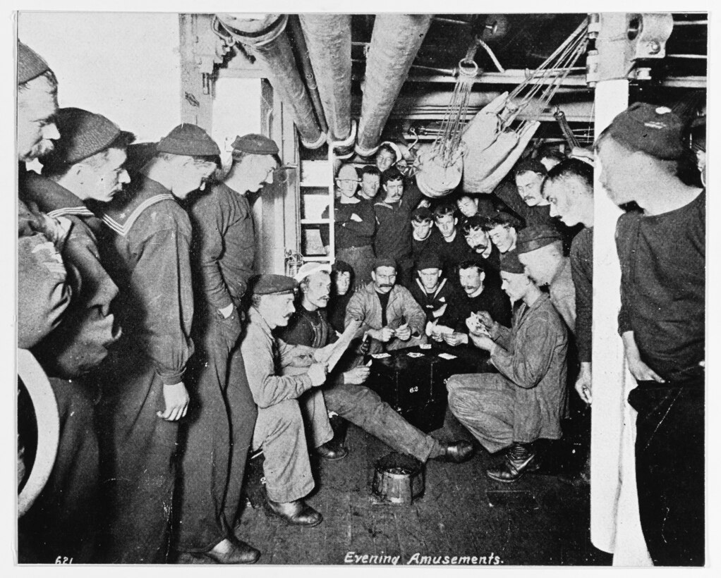 Evening Amusements: crewmembers playing cards and reading in their berthing spaces, circa 1895-1898. Halftone photograph, copied from the contemporary publication Uncle Sam's Navy, 1898. U.S. Naval History and Heritage Command Photograph.