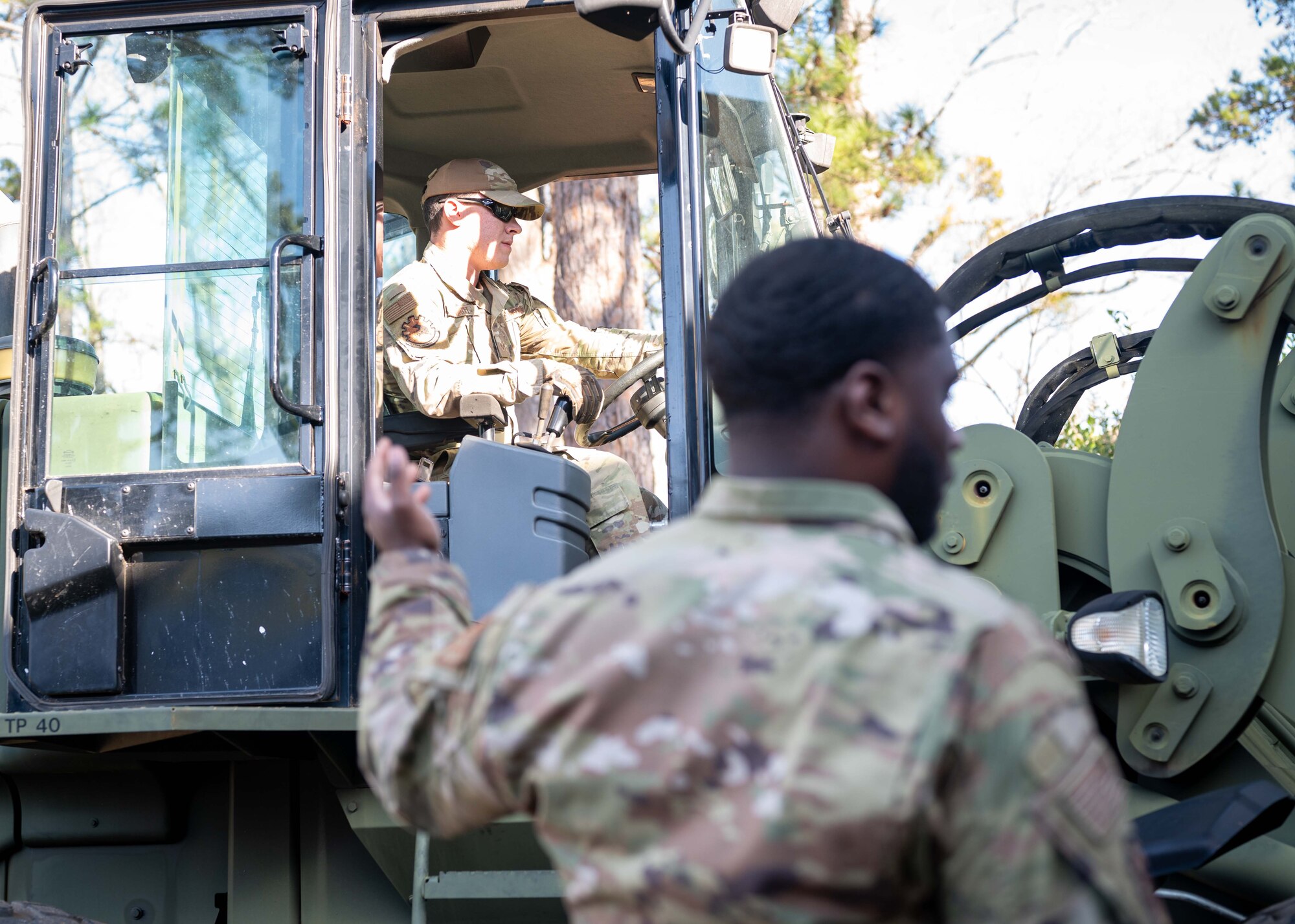An Airman assists a fellow Airman with heavy machinery at the Carolina Skies Club.
