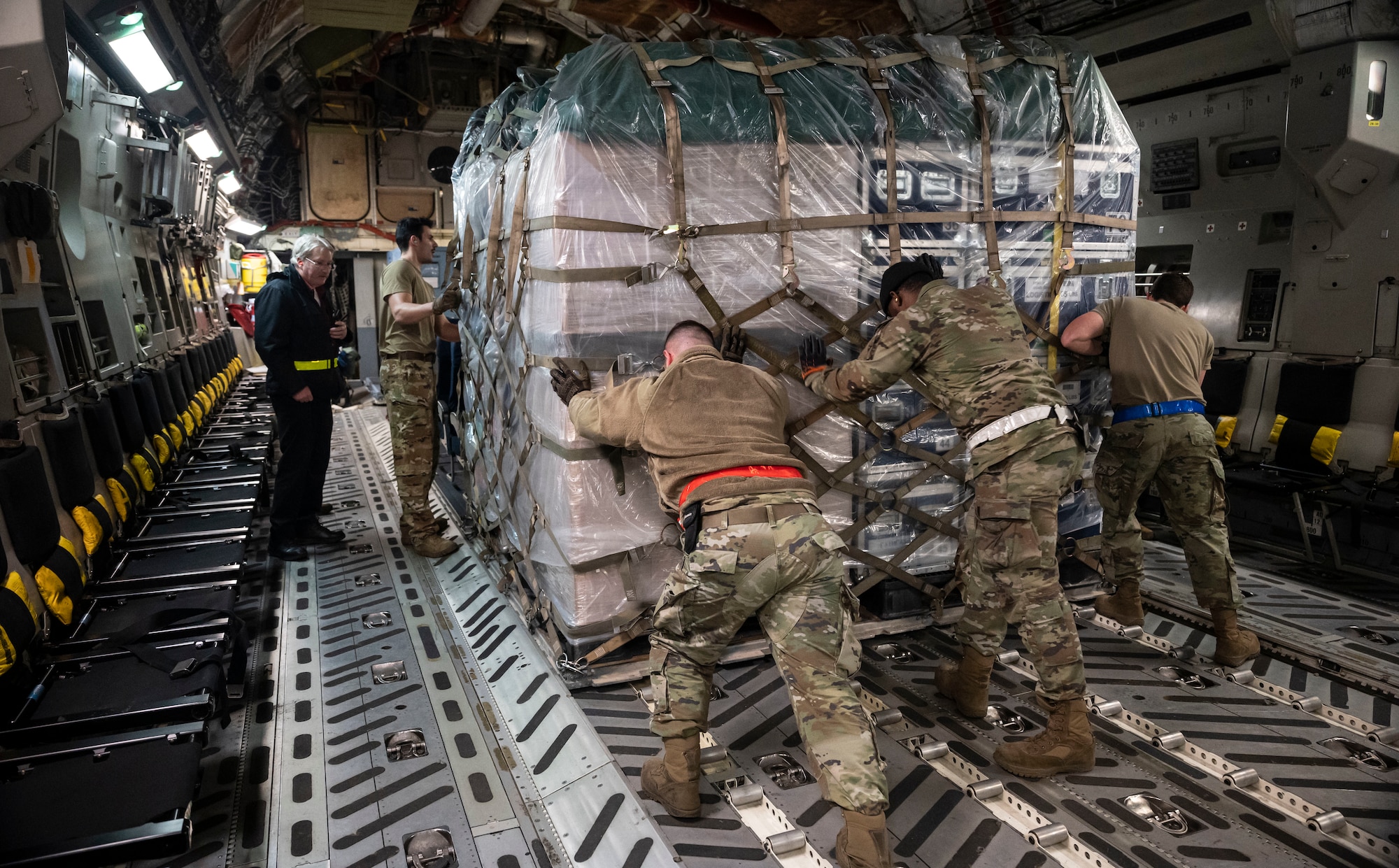 Airmen from the 436th Aerial Port Squadron load a pallet of cargo onto a C-17 Globemaster III on Dover Air Force Base, Delaware, Feb. 7, 2023. The U.S. Agency for International Development (USAID) is mobilizing emergency humanitarian assistance to respond to the devastating impacts in Türkiye following the worst earthquake to hit the region in almost a century. (U.S. Air Force photo by Staff Sgt. Marco A. Gomez)