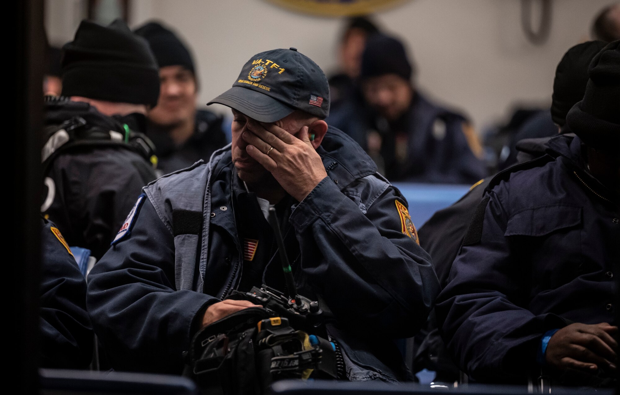 An Urban Search and Rescue member from Fairfax County, Virginia, rubs his eyes while waiting to board a C-17 Globemaster III on Dover Air Force Base, Delaware, Feb. 7, 2023. The U.S. Agency for International Development (USAID) is mobilizing emergency humanitarian assistance to respond to the devastating impacts in Türkiye following the worst earthquake to hit the region in almost a century. (U.S. Air Force photo by Staff Sgt. Marco A. Gomez)