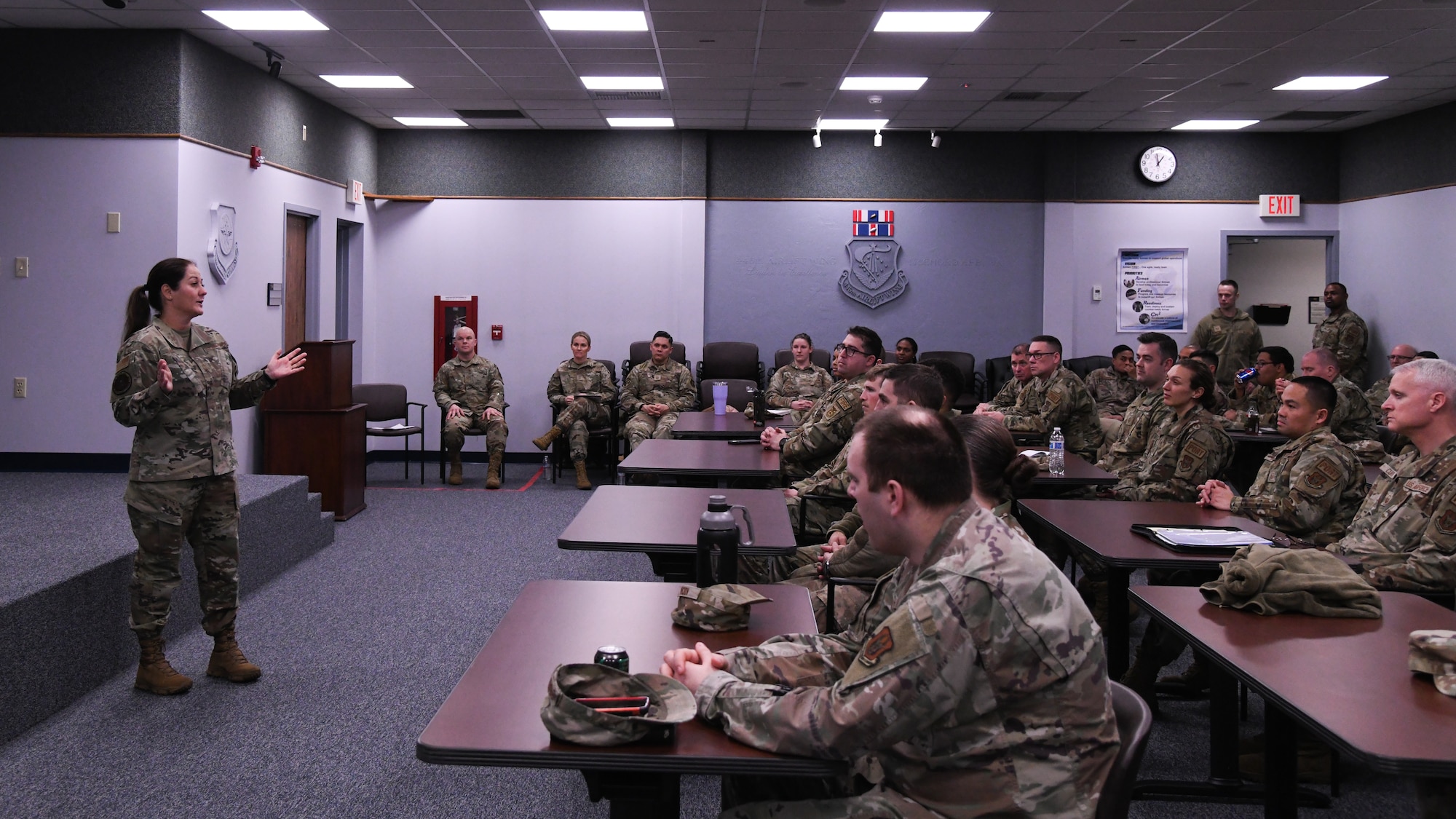 CMSgt Sarah Faith lectures from the front of the wing auditorium to a room of Reservists.