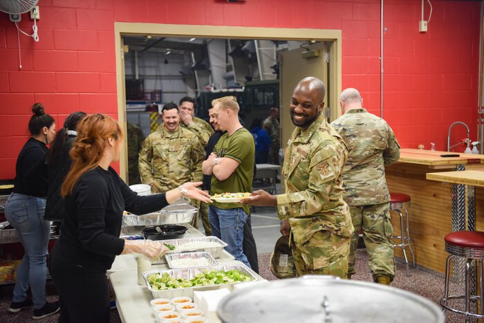Members of the 312th Training Squadron eat lunch during Operation Feed Everyone at the Louis F. Garland Department of Defense Fire Academy, on Goodfellow Air Force Base, Texas, Feb. 6, 2023. Operation Warm Heart members served tacos to the 312th TRS to reward them for all their hard work. (U.S. Air Force photo by Staff Sgt. Tyrell Hall)