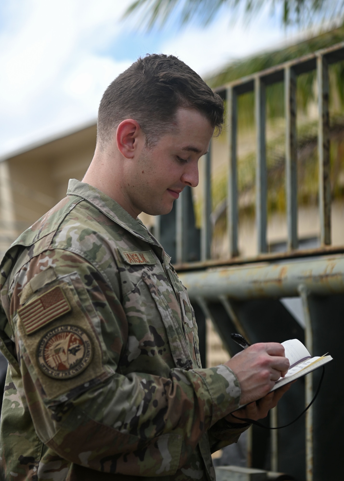U.S. Air Force 1st Lt. Colin Zavislak, lead member of the Project Arc cohort in the Pacific Air Forces region, writes notes while on a walk-through of the 36th Contingency Response Squadron at Andersen Air Force Base, Guam, Jan. 30th, 2023. There is a new program emerging across the Air Force called Project Arc, which enables a few select uniformed scientists and engineers to work directly with operational users to solve problems at the point of impact. Zavislak and two others in the cohort are the first Project Arc team to enter the Pacific Air Forces, spending six months among three bases in the region. (U.S. Air Force photo by Staff Sgt. Aubree Owens)