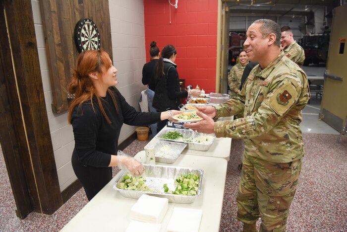 A Goodfellow Air Force Base spouse serves a plate of food to Senior Master Sgt. Kevin Johnson, 316th Training Squadron first sergeant, during Operation Feed Everyone at the Louis F. Garland Department of Defense Fire Academy, on GAFB, Texas, Feb. 6, 2023. Operation Warmheart, run by the Goodfellow First Sergeants Council, hosted this event. (U.S. Air Force photo by Staff Sgt. Tyrell Hall)