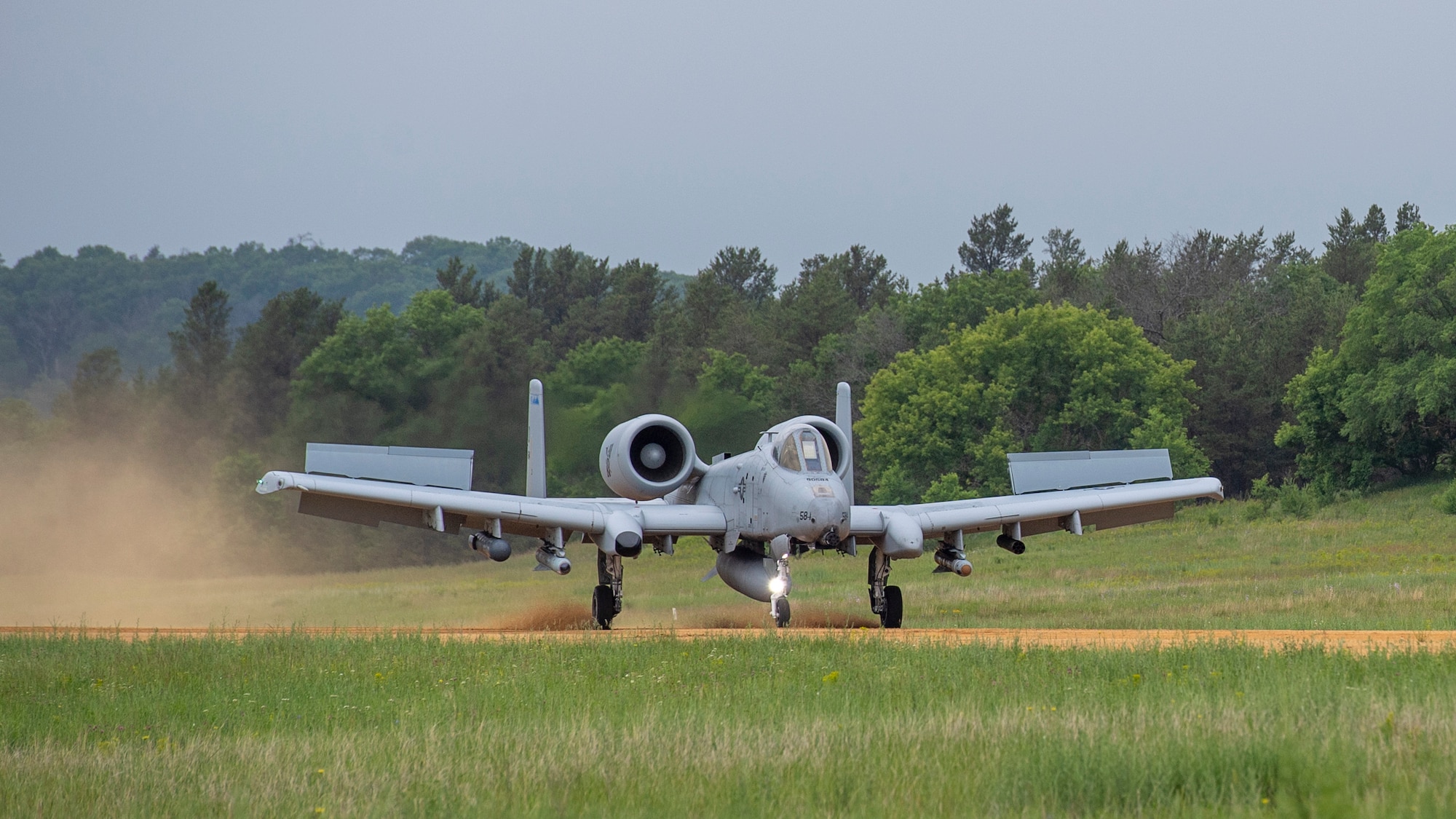 An A-10 Thunderbolt II landing on a dirt runway