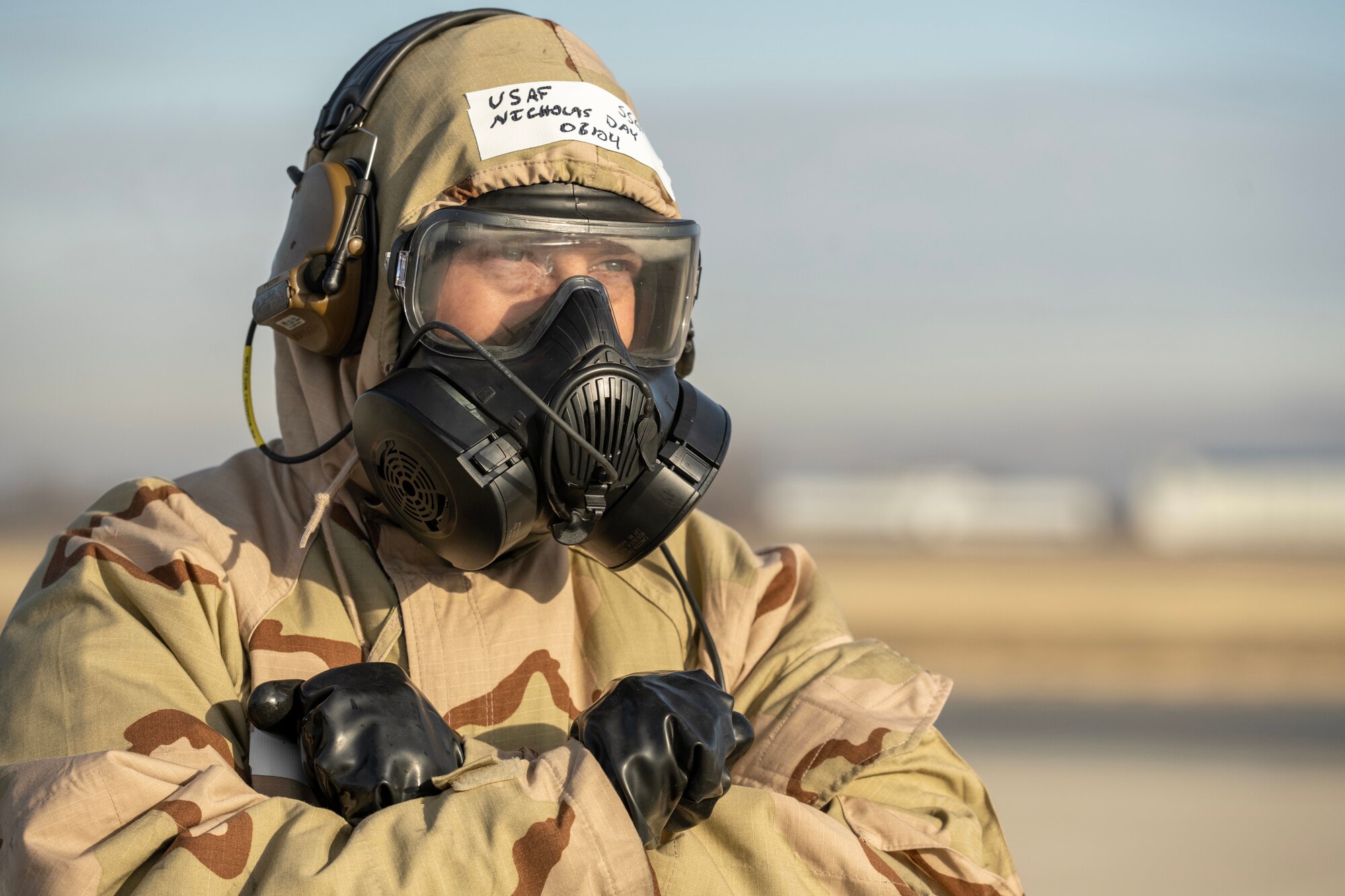 An Airman wears a chemical warfare suite while launching an aircraft