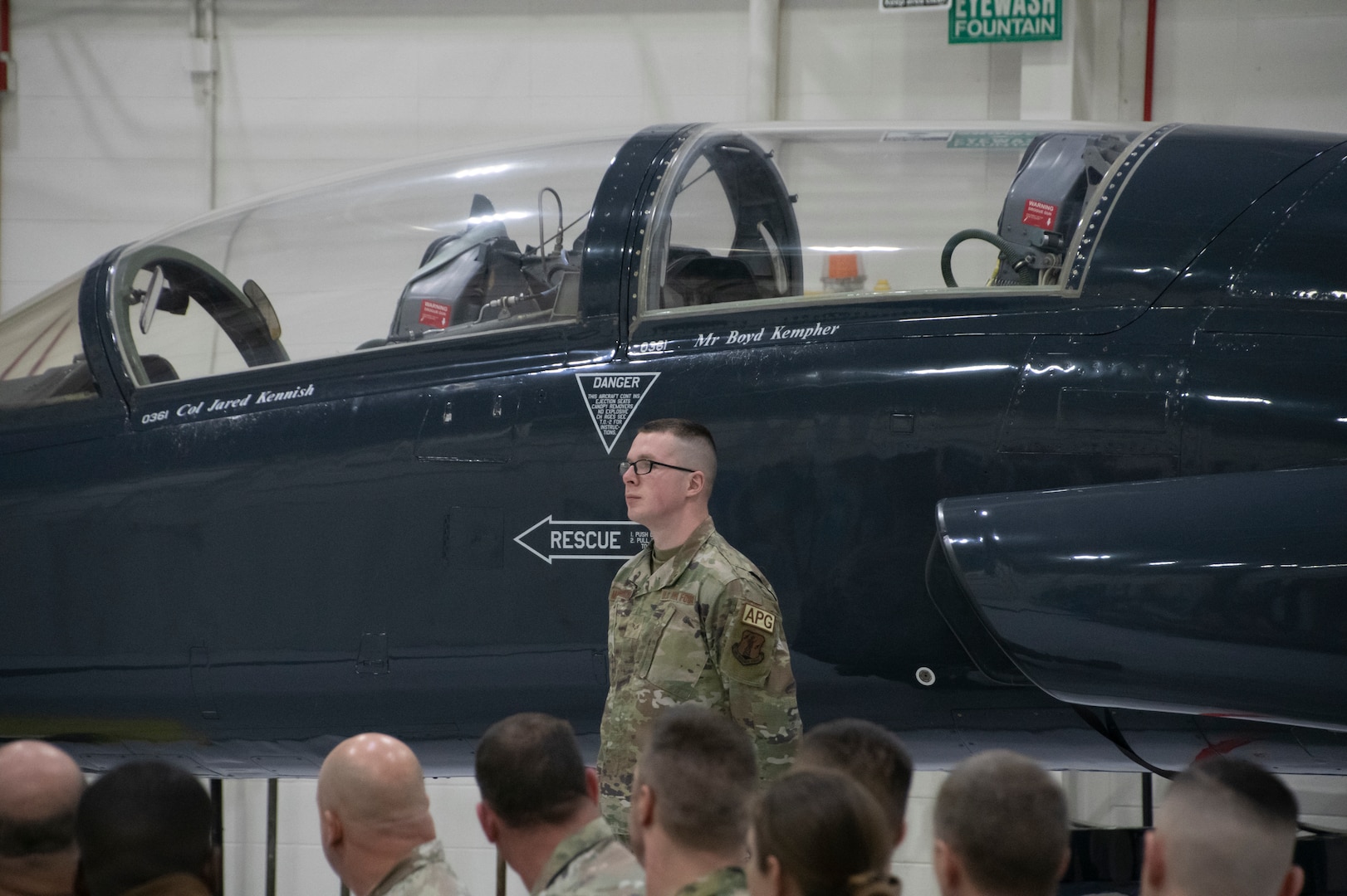 Senior Airman Justin Meinershagen, 131st Bomb Wing maintainer, stands at parade rest after revealing the newly-added name of Col. Jared Kennish to a T-38 Talon trainer jet during a change of command ceremony at Whiteman Air Force Base, Missouri, Feb. 3, 2023. During the ceremony Col. Jared P. Kennish assumed command of the 131st Bomb Wing from Col. Matthew D. Calhoun. (U.S. Air National Guard photo by Senior Airman Kelly C. Ferguson)