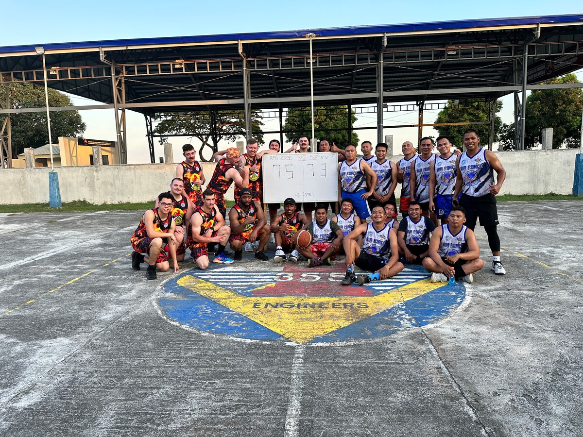 Airmen from the 819th RED HORSE Squadron out of Malmstrom Air Force Base, Montana, pose alongside their Philippine Air Force counterparts after a game of pick-up basketball at Basa Air Base, Philippines, February 1, 2023. The RED HORSE Squadron was in the Philippines as part of a Field Training Event and spent time with their PAF counterparts building an airfield damage repair training pad. While the Airmen from the 819th were in the Philippines to pour concrete, they learned much more from their counterparts on and off the job. They shared special moments with each other including promotions, birthdays, culture, cuisine, and language. (U.S. Air Force photo by Tech. Sgt. Hailey Haux)