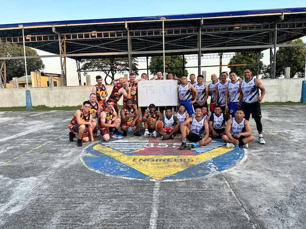 Airmen from the 819th RED HORSE Squadron out of Malmstrom Air Force Base, Montana, pose alongside their Philippine Air Force counterparts after a game of pick-up basketball at Basa Air Base, Philippines, February 1, 2023. The RED HORSE Squadron was in the Philippines as part of a Field Training Event and spent time with their PAF counterparts building an airfield damage repair training pad. While the Airmen from the 819th were in the Philippines to pour concrete, they learned much more from their counterparts on and off the job. They shared special moments with each other including promotions, birthdays, culture, cuisine, and language. (U.S. Air Force photo by Tech. Sgt. Hailey Haux)