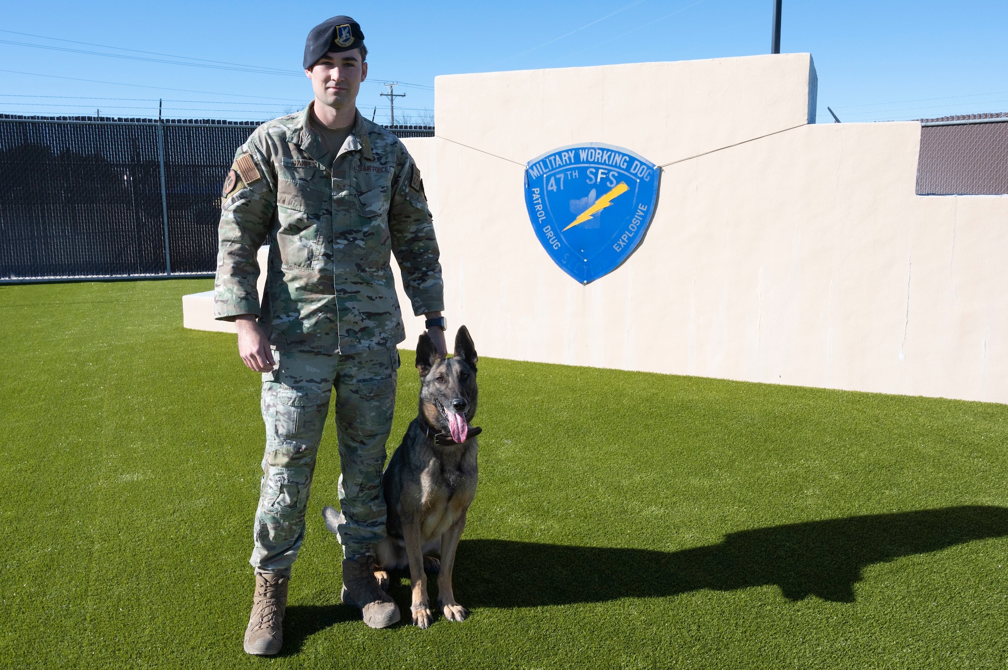 U.S. Air Force Staff Sgt. Charles Gaines, 47th Security Force Squadron military working dog trainer, poses with Tuko, a military working dog, at the 47th Security Forces Squadron military working dog training area at Laughlin Air Force Base, Texas, on Jan. 13, 2023. MWD handlers employ their dogs to conduct vehicle searches, and searches of open areas, buildings, and other locations for the detection of suspects, explosives or illegal drugs. (U.S. Air Force photo by Airman 1st Class Kailee Reynolds)