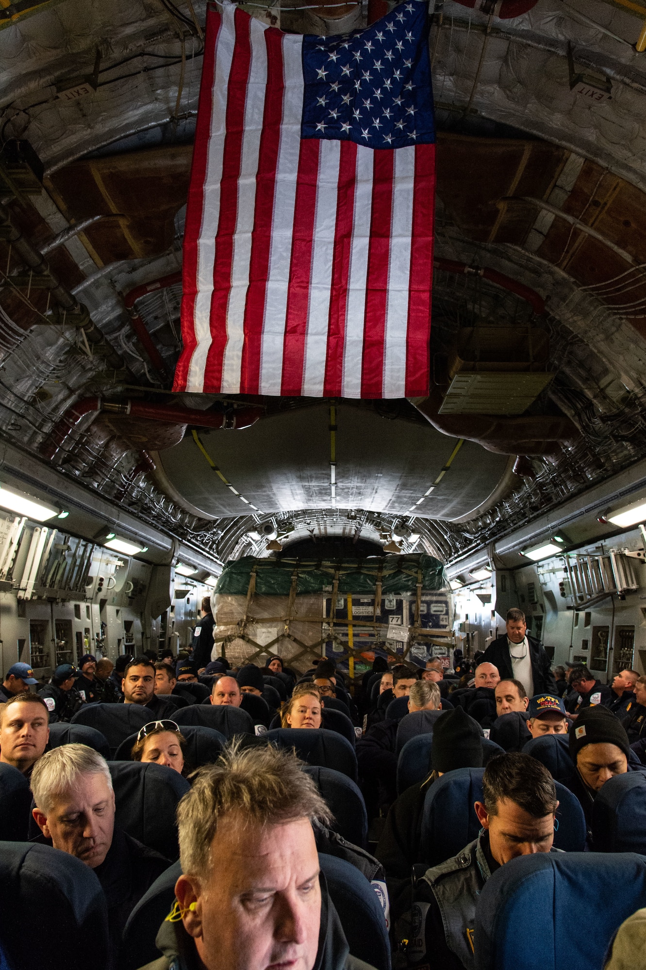Members of Urban Search and Rescue Virginia Task Force 1, Fairfax County, Virginia, sit onboard a C-17 Globemaster III prior to departing Dover Air Force Base, Delaware, Feb. 7, 2023. The U.S. Agency for International Development (USAID) is mobilizing emergency humanitarian assistance to respond to the devastating impacts in Türkiye following the worst earthquake to hit the region in almost a century. (U.S. Air Force photo by Roland Balik)