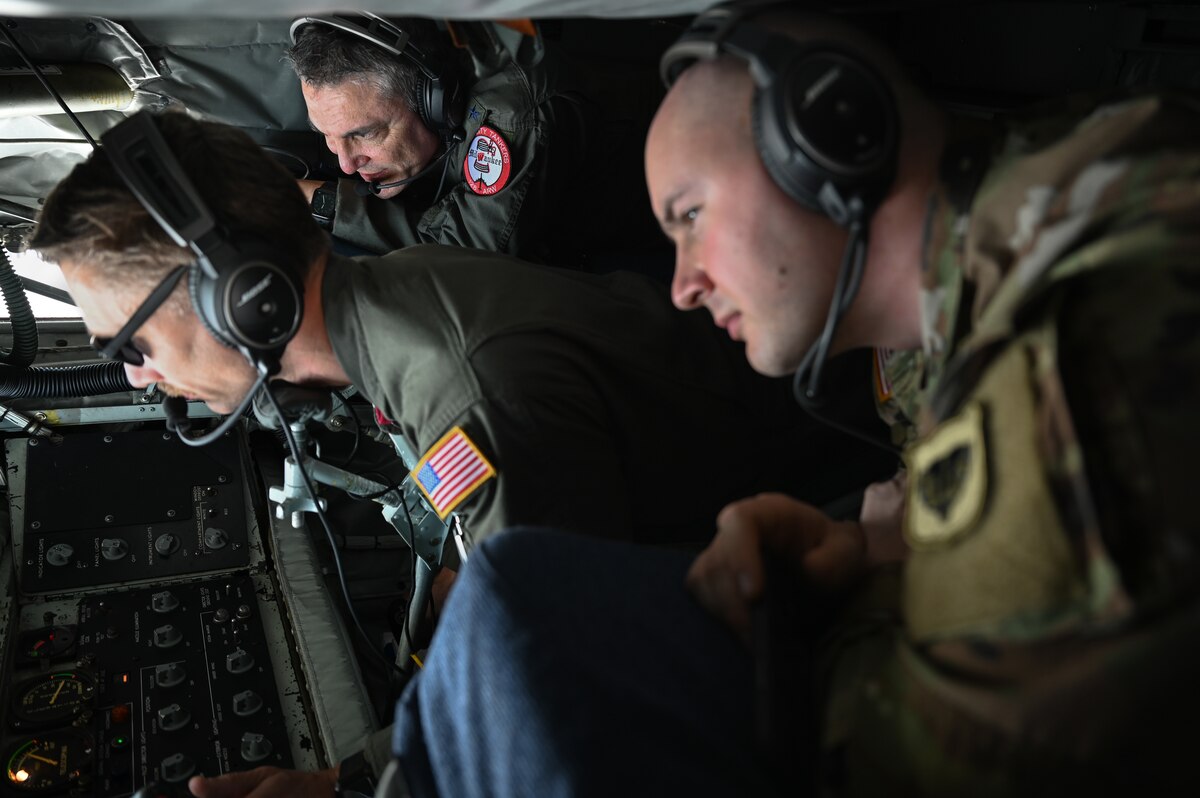 U.S. Air Force Maj. Gen. Paul Knapp, adjutant general of the Wisconsin Air National Guard, U.S. Army Capt. Mark Gerasimov, Wisconsin National Guard aide de camp to the adjutant general, and U.S. Air Force Master Sgt. Justin Jung, 128th Aerial Refueling Wing boom operator, watch the boom as it refuels a U.S. Air Force B-1B Lancer, over the Pacific Ocean, Feb. 3, 2023.