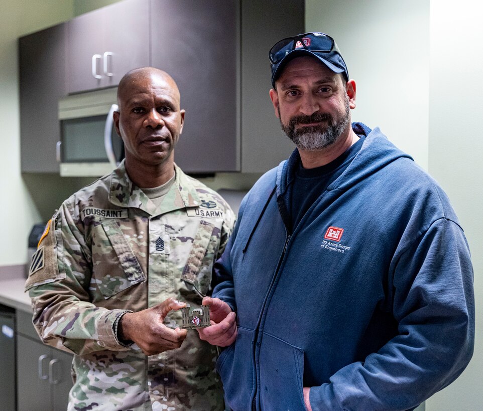 Command Sgt. Maj Patrickson Toussaint, the top senior enlisted advisor for the U.S. Army Corps of Engineers, presents a command coin to Michael Ritchey, equipment mechanic for the Pittsburgh District, at the Monongahela River Locks and Dam 4 in Charleroi, Pennsylvania, Jan. 30, 2023. Military leaders present customized coins to civilian and military service members to show appreciation for a job well done worthy of recognition. Toussaint spent several days speaking to employees across the district to gain a better perspective of their responsibilities and roles in supporting the corps’ mission in the greater Pittsburgh region. (U.S. Army Corps of Engineers Pittsburgh District photo by Michel Sauret)