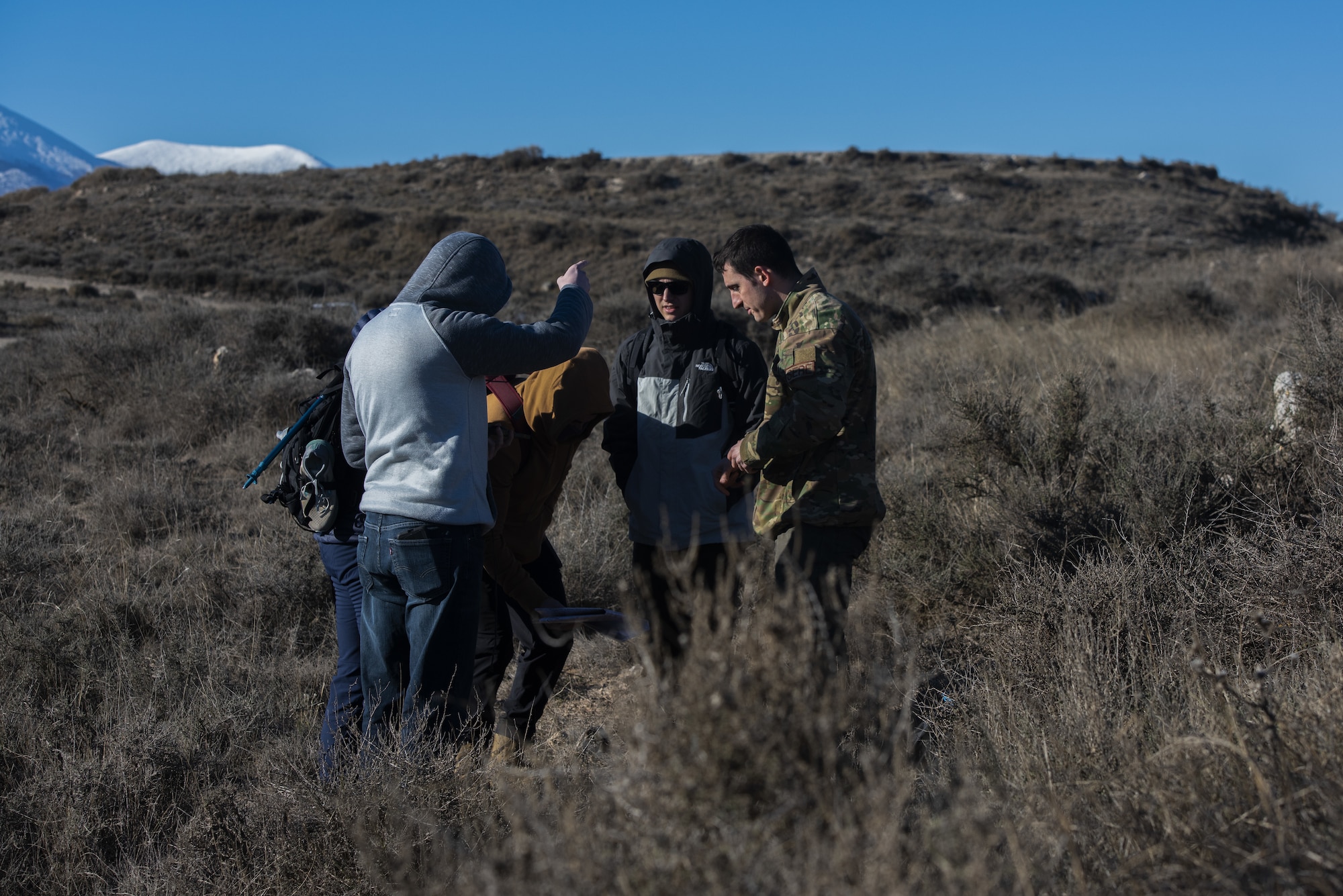 Five people stand together and look at a map