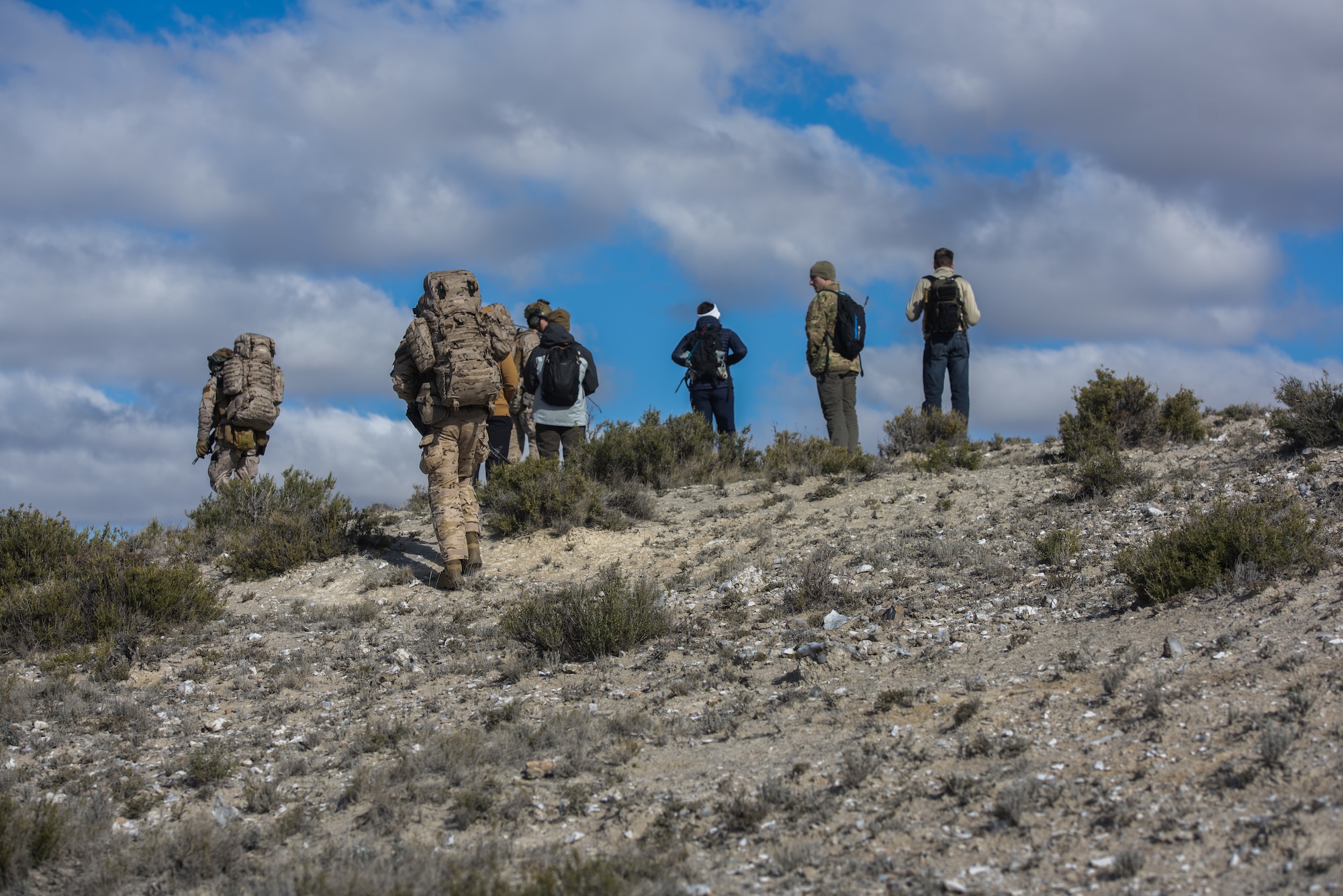 Eight people hike up a hill