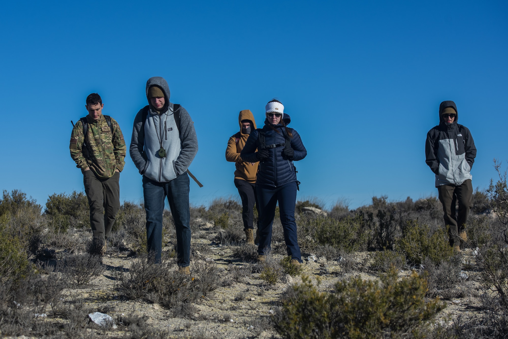 A view of five people hiking through mountains