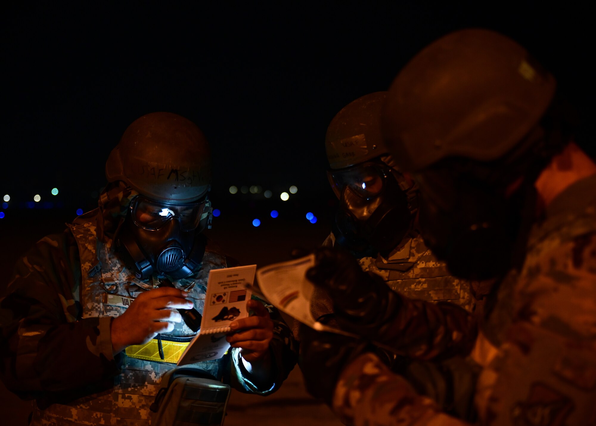 U.S Air Force Master Sgt. David Varady (left), 80th Fighter Generation Squadron (FGS) flightline expediter, Senior Airman Joshua Gabb (center), 80th FGS specialist, and Master Sgt. Robert Pray, 80th FGS crew chief, review their Airman’s Manual quick reference cards during a post-attack reconnaissance sweep training event at Kunsan Air Base, Republic of Korea, Feb. 6, 2023. After donning mission oriented protective posture gear, 80th FGS maintainers swept the flightline in search of simulated chemical contamination or unexploded ordnance to ensure the flightline remains safe to continue operations. (U.S. Air Force photo by Staff Sgt. Isaiah J. Soliz)