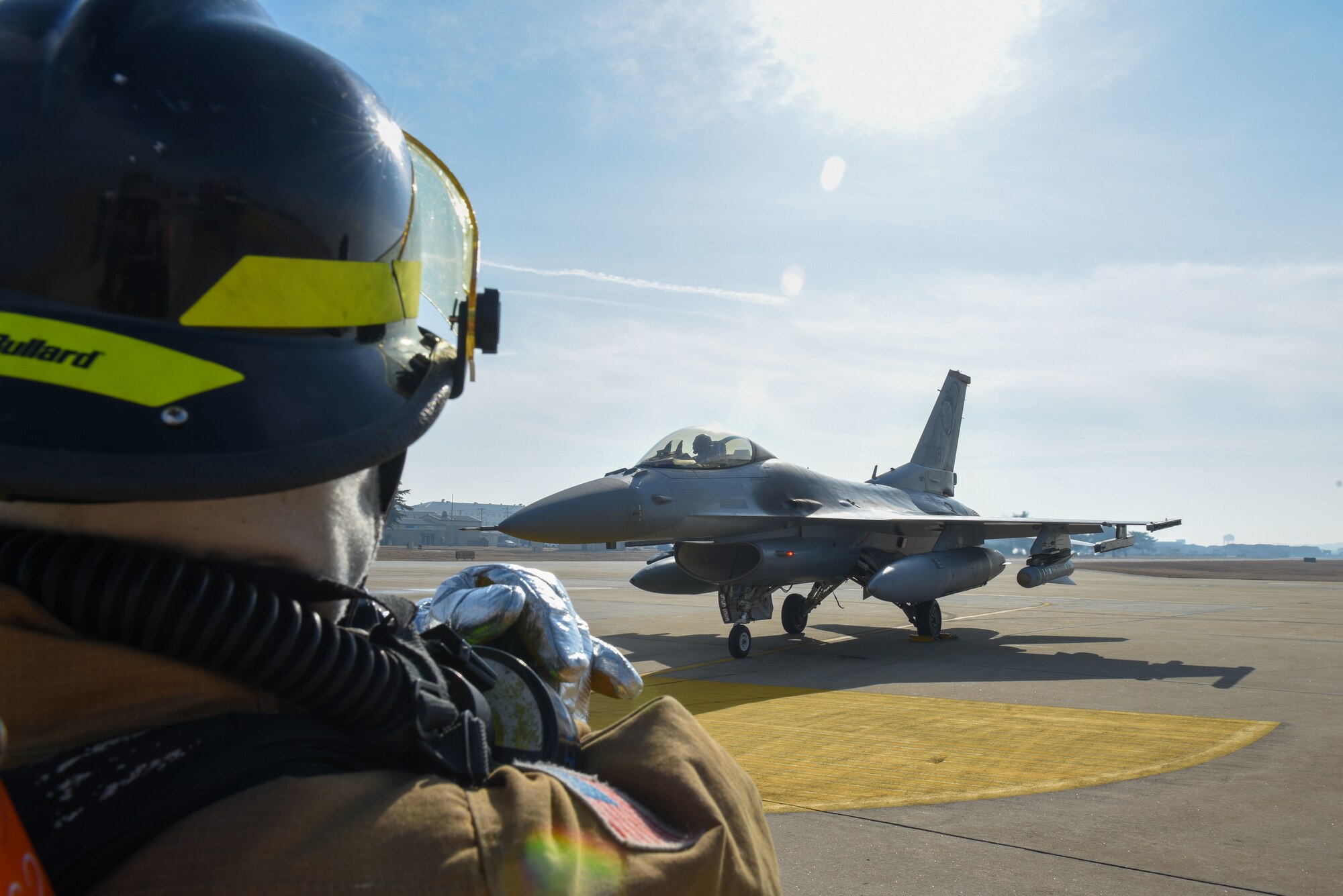 U.S. Air Force Airman 1st Class Jadon Davis, 8th Civil Engineer Squadron firefighter, halts a Republic of Korea (ROK) Air Force KF-16 Fighting Falcon during a simulated in-flight emergency training event at Kunsan Air Base, ROK, Feb. 6, 2023. During the training, personnel responded within minutes to simulate extinguishing a fire on the aircraft. (U.S. Air Force Photo by Tech. Sgt. Timothy Dischinat)