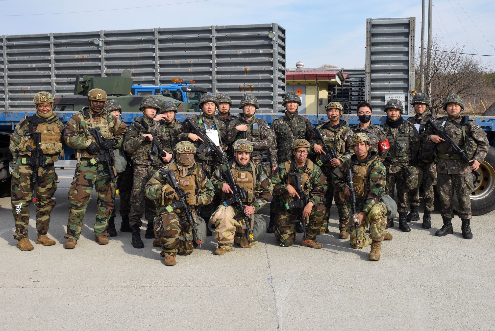 Military police officers and logistics personnel from the Republic of Korea (ROK) Air Force 38th Fighter Group and defenders from the U.S. Air Force 8th Security Forces squadron pose for a photo after a simulated munitions transport training event at Kunsan Air Base, ROK, Feb. 6, 2023. A testament to their interoperability, the two services delivered the simulated payload onto the installation and into the munition’s storage area. (U.S. Air Force photo by Senior Airman Akeem K. Campbell)